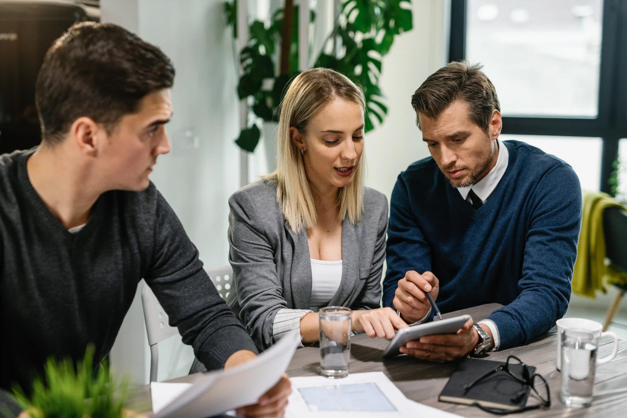 groupe de personne avec des plans, calculatrice et tablette